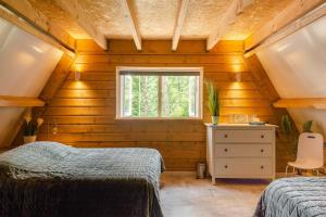 a bedroom with two beds and a window at Chalet Citola in Nuenen