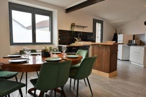 a dining room with a table and green chairs at La Champtocette de la Loire in Champtoceaux