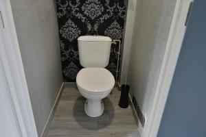 a white toilet in a bathroom with a black wall at La Champtocette de la Loire in Champtoceaux