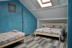 a bedroom with two beds and a blue wall at La Champtocette de la Loire in Champtoceaux