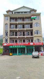 a large building with a car parked in front of it at Paradise Banihal Hotel in Banihāl