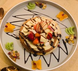a plate with a cake with fruit on it at Hotel Tenki Kathmandu in Kathmandu