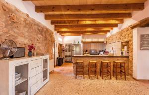 a kitchen with wooden ceilings and a stone wall at Holiday Home Finca Ses Tanques in Algaida