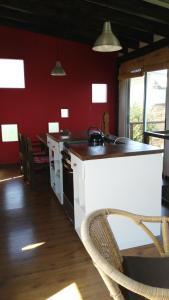 a kitchen with red walls and a white counter top at La Retobada in La Pedrera