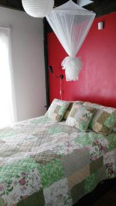 1 dormitorio con cama y pared roja en La Retobada, en La Pedrera
