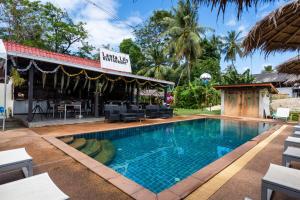 a pool at a resort with a restaurant at Mook Lanta Eco Resort in Ko Lanta