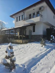 a house with a snow covered yard in front of it at "Бадевски рай" Къща за гости ВЯРА in Elena