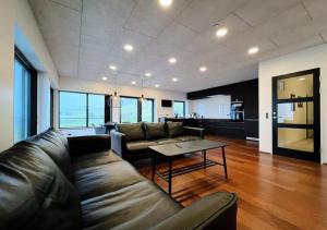 a living room with a leather couch and a table at Penthouse by Krambatangi in Øravík