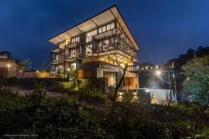 a house with a lit up facade at night at Sathkara Resort Ella in Ella