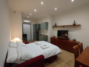 a bedroom with a white bed and a television at Patecchio2-IEO Fondazione Prada Villaggio Olimpico in Vigentino