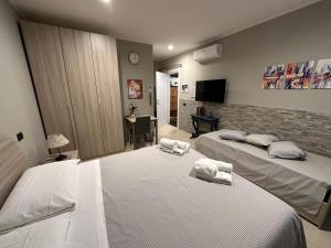 a bedroom with two beds with towels on them at Bed & Breakfast Indi Thelar in Villa Guardia
