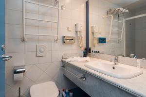 bagno con lavandino, servizi igienici e telefono di Cozy loft near Old Town a Tallinn
