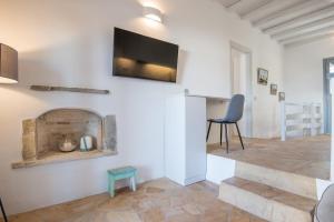 a living room with a fireplace and a tv on the wall at Seaview Villa Euterpe in Ambelas