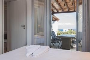 a bedroom with a bed and a balcony with a table at Seaview Villa Euterpe in Ambelas
