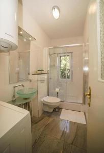 a bathroom with a sink and a toilet and a shower at Spacious beach apartment in Razvala