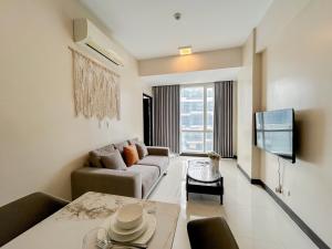 a living room with a couch and a table at Modern 1BR w Exclusive Pool Access in Lapu Lapu City