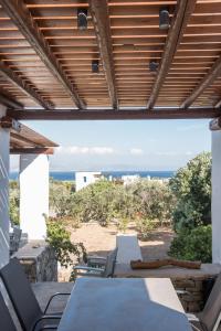 a patio with tables and chairs and a view of the beach at Seaview Villa Euterpe in Ambelas