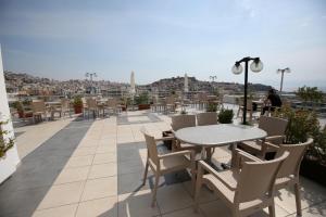 a patio with tables and chairs on a roof at Oceanis Hotel in Kavála