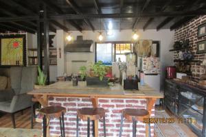 a kitchen with a counter and stools in a room at BIG J'S Farm House in Dhulikhel