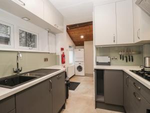 a kitchen with white cabinets and a sink at Norwood House in Ambleside