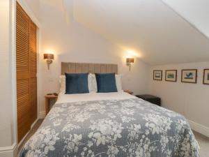 a bedroom with a large bed with blue pillows at Norwood House in Ambleside