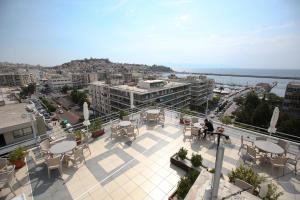 a balcony with tables and chairs on a building at Oceanis Hotel in Kavála
