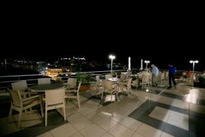 a table and chairs on a balcony at night at Oceanis Hotel in Kavála