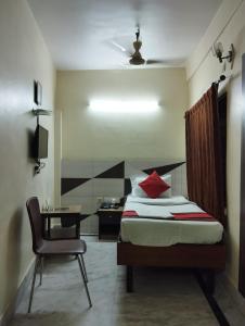 a bedroom with a bed and a chair and a desk at Welcome Regency in kolkata +22 photos