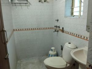 a white bathroom with a toilet and a sink at Welcome Regency in kolkata