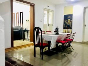 a dining room with a table and chairs and a mirror at Angels Negombo in Negombo