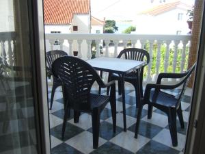 a table and four chairs on a balcony at Apartmani kod Rade in Pakoštane