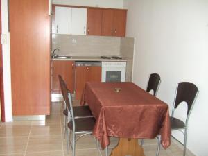 a kitchen with a table and chairs and a kitchen with a table and a table at Apartmani kod Rade in Pakoštane