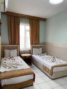 two beds sitting in a room with a window at Best Life Apart Hotel in Alanya