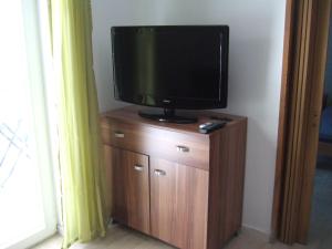 a television sitting on top of a wooden cabinet at Apartmani kod Rade in Pakoštane