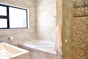 a large bathroom with a tub and a sink at Foreshore 2 Sea View Holiday accommodation in Langstrand +18 photos