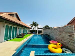 a swimming pool with two rubber ducks next to a house at The Villa Jomtien Pattaya By Ahmed in Jomtien Beach