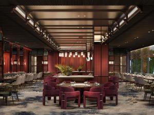 a restaurant with red walls and tables and chairs at Pullman Kuching in Kuching