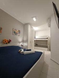 a bedroom with a large bed with a blue blanket at Lilli & Evoque Apartments in Civitanova Marche