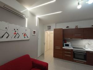 a living room with a red couch in a kitchen at Lilli & Evoque Apartments in Civitanova Marche