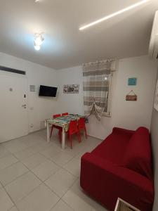 a living room with a red couch and a table at Lilli & Evoque Apartments in Civitanova Marche