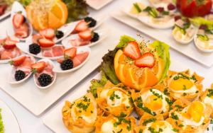 a table filled with plates of food with fruit at Hotel Wit Stwosz in Krakow