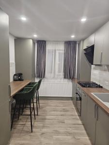 a kitchen with a table and chairs and a window at Trusted Home in Târgovişte +8 photos