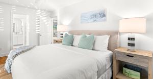 a bedroom with a white bed and a lamp at Sugar in Santa Rosa Beach