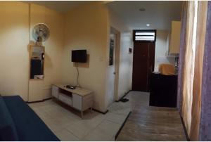a living room with a room with a television and a room with at Alegre Building Lipa in Lipa