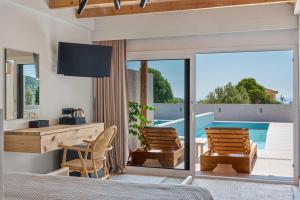 a bedroom with a bed and a desk and a pool at Pacifae Hotel in Katelios