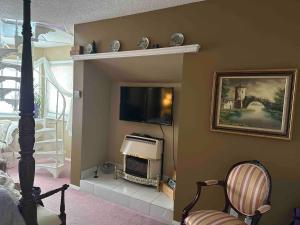 a living room with a tv on a wall at Charming Victorian Home in Okotoks Elegant Comfort Modern Convenience in Okotoks
