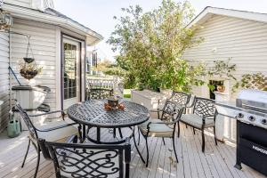 a patio with a table and chairs and a stove at Charming Victorian Home in Okotoks Elegant Comfort Modern Convenience in Okotoks