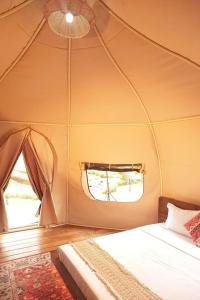 a bedroom with a tent with a bed and a window at The Silkroad Mũi Né in Ấp Khánh Phước (1)