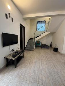 a living room with a staircase and a flat screen tv at New Moon Resort in Chennai