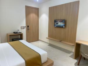 a hotel room with a bed and a desk and a table at Hotel Immense Plaza in Jāmb +25 photos